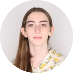 Headshot of Robyn Aurora Watkins, a young woman with long brown hair wearing a floral yellow and white patterned shirt against a light gray circular background.