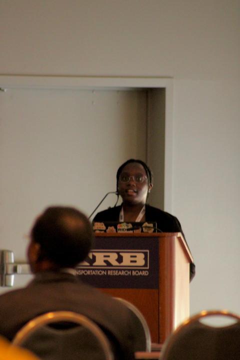 Speaker at a Transportation Research Board podium addressing an audience during a presentation or conference.